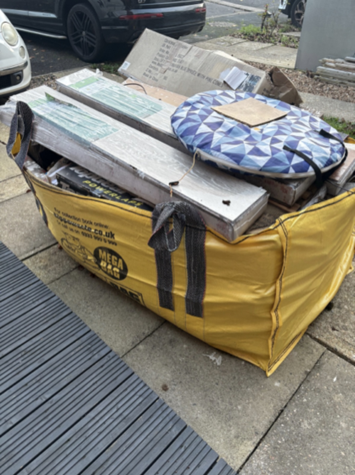 Mega bag filled with mixed DIY and building waste on a driveway.